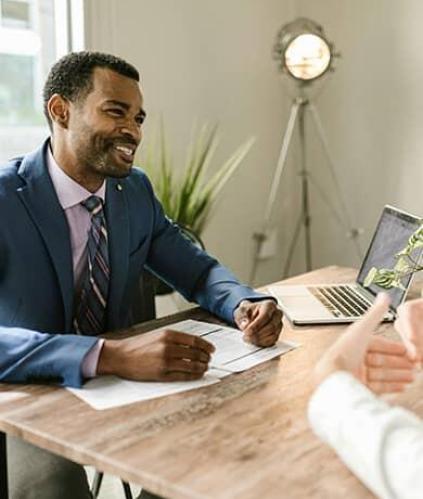 Deux hommes dans un bureau souriant, prise de conseil pour la création d'entreprise