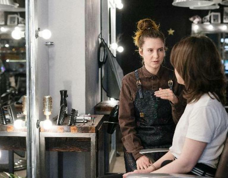 Une cliente et sa coiffeuse ans un salon de coiffure pour illustrer l'expertise d'accompagnement de Cerfrance dans les métiers de la coiffure et de la beauté