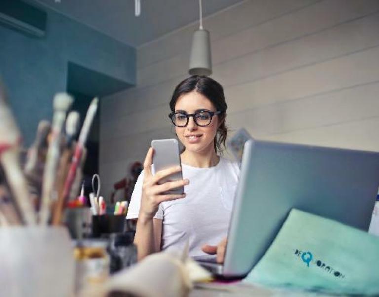 Une femme tenant un téléphone entouré par des pinceaux pour illustrer l'expertise d'accompagnement de Cerfrance dans les métiers pour les particuliers