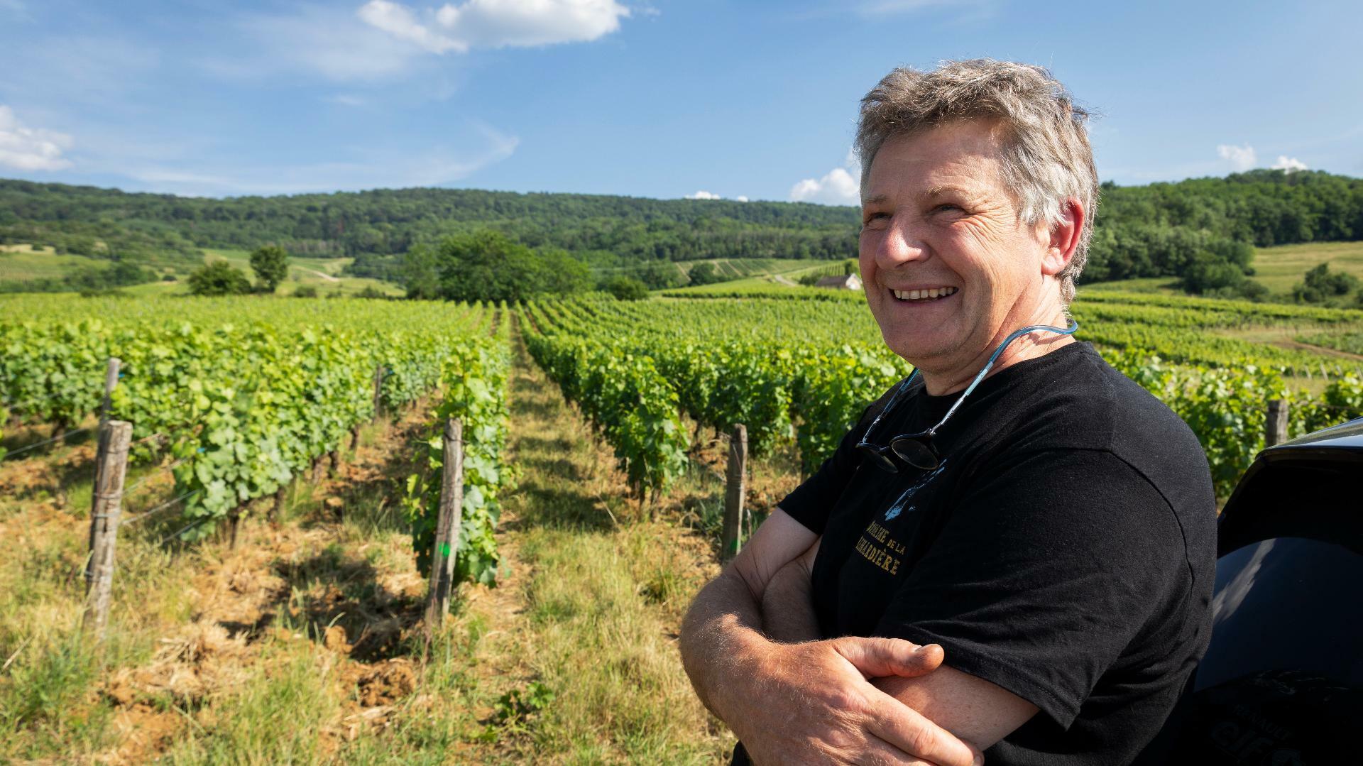 Un homme viticulteur devant son vignoble pour illustrer l'expertise d'accompagnement de Cerfrance dans les métiers de la viticulture