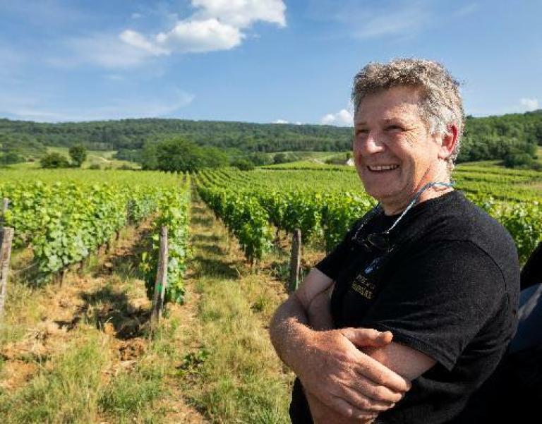 Un homme viticulteur devant son vignoble pour illustrer l'expertise d'accompagnement de Cerfrance dans les métiers de la viticulture