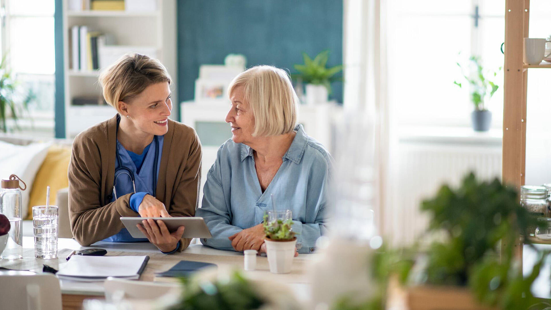 Une femme et un vieille femme en discussion devant une tablette - Découvrez notre expertise des services