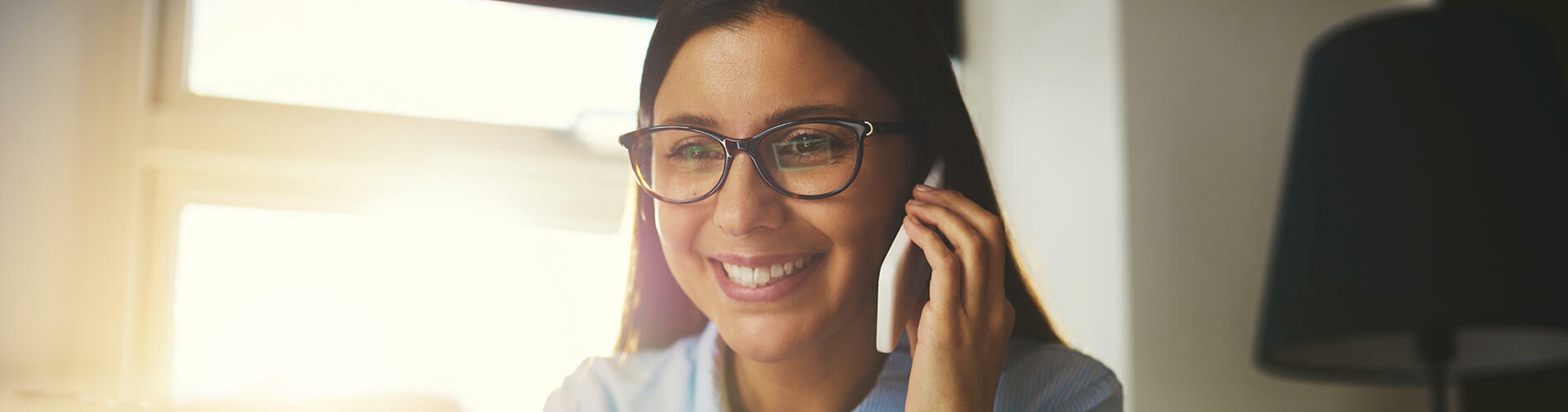 femme au téléphone à son bureau, découvrez notre expertise des Particuliers