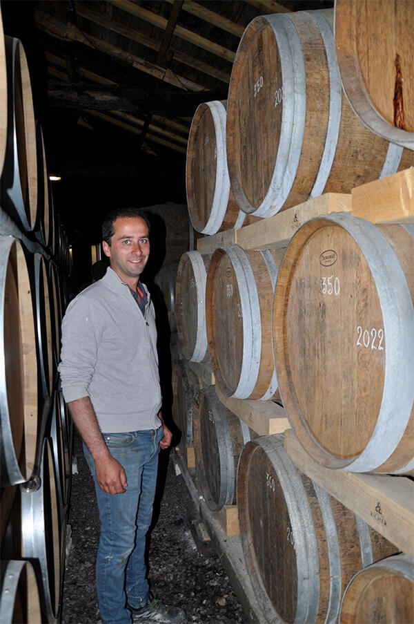 Homme dans sa cave entre des fûts de Cognac