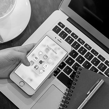 Personne regardant son téléphone avec les icônes des réseau sociaux