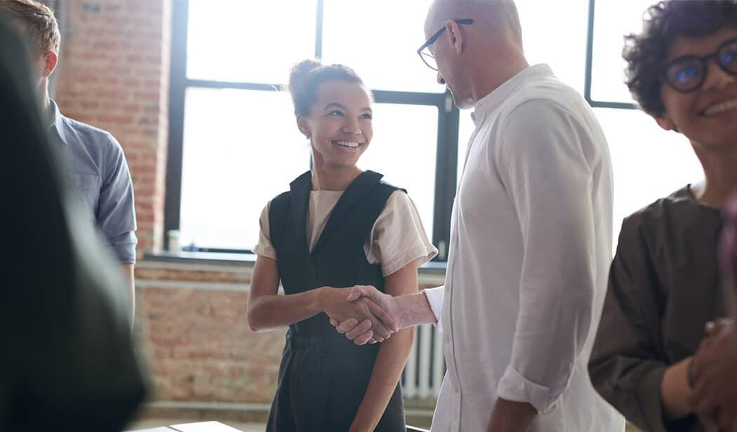 Femme et homme se serrant la main pendant un entretien d'embauche