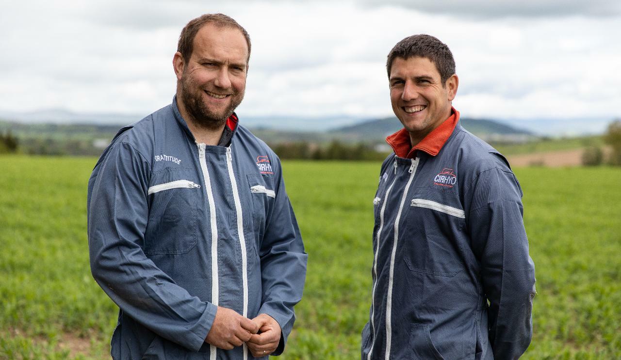 Deux agriculteurs souriant en blouse de travail