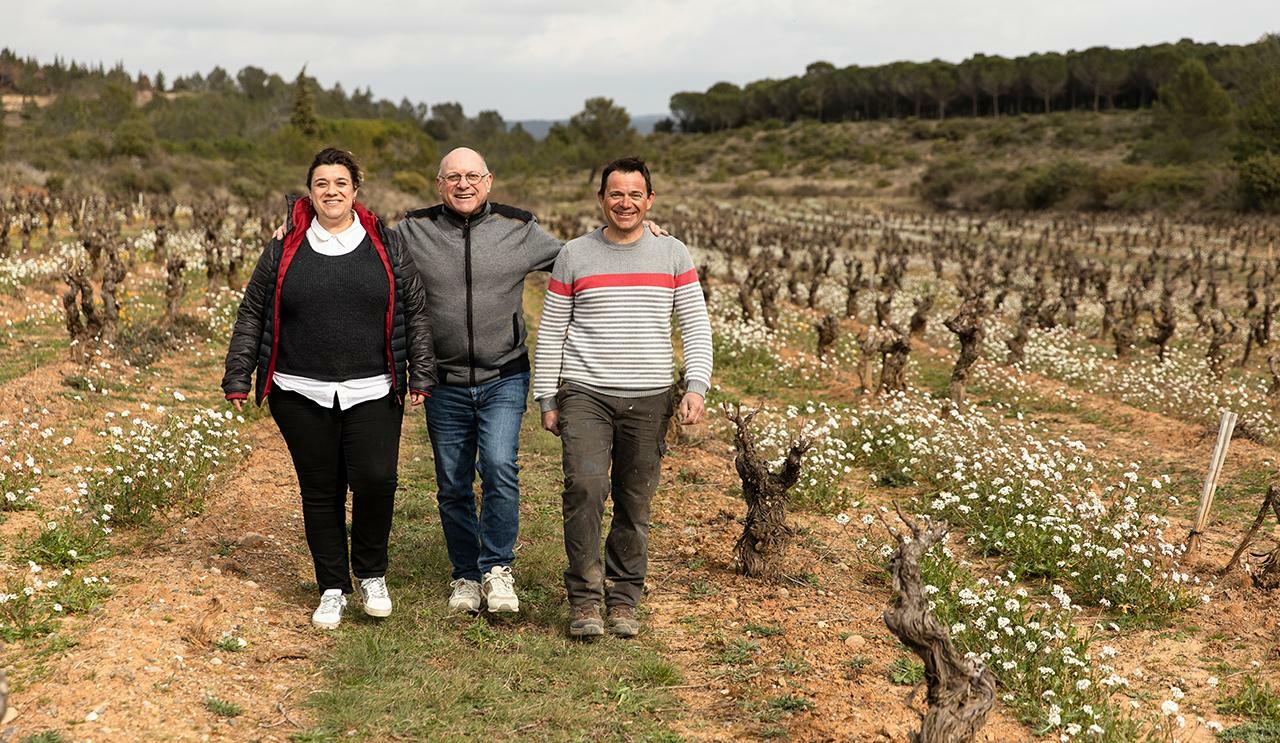 Un client-adhérent agricole dans son exploitation viticole avec son fils et sa fille qui vont reprendre l'exploitation